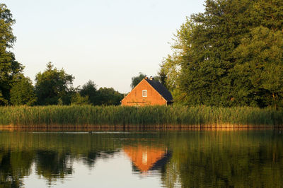 Scenic view of lake by building against sky