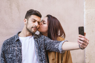 Young couple holding mobile phone outdoors