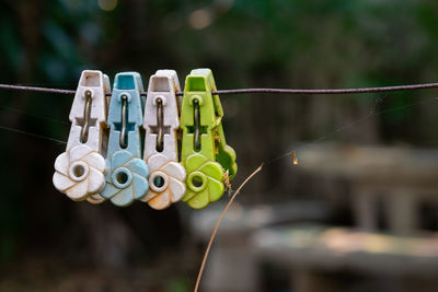 Close-up of clothespins hanging on rope