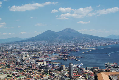 High angle view of city by sea against sky