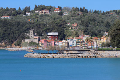 Scenic view of river by buildings against sky