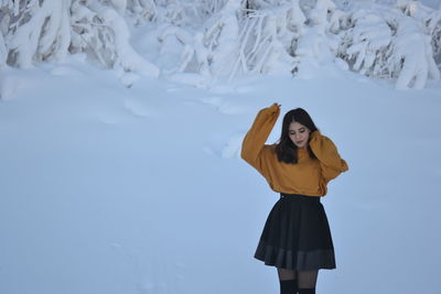 Fashionable teenage girl standing in snow