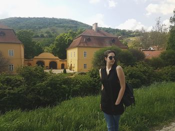 Full length of woman standing on grass against trees
