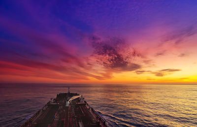 Scenic view of sea against dramatic sky during sunset