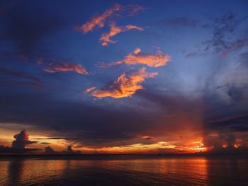 Scenic view of sea against dramatic sky during sunset