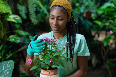 Young woman looking away while holding plant