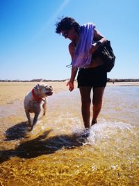  woman running in sea with dog