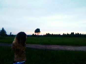 Rear view of woman on field against sky