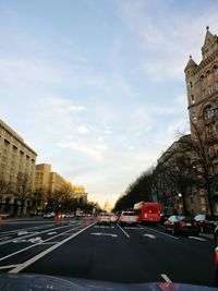 Cars on road in city against sky