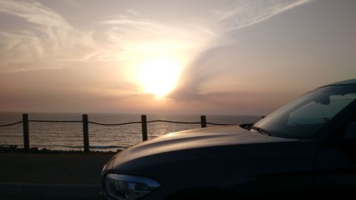Close-up of car on sea against sky during sunset