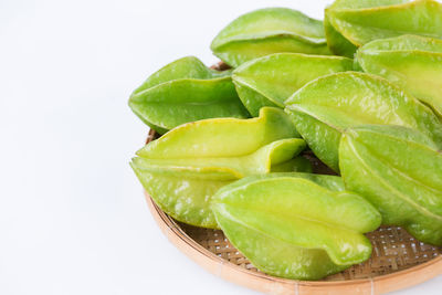 Close-up of green fruit against white background