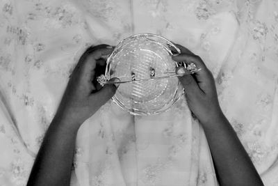 Cropped hands holding basket on table