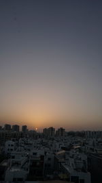 Cityscape against clear sky at sunset