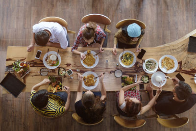 High angle view of people sitting on table