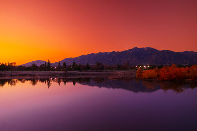 Scenic view of lake against clear sky during sunset