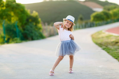 Portrait of young woman standing on road