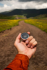 Cropped hand holding navigational compass