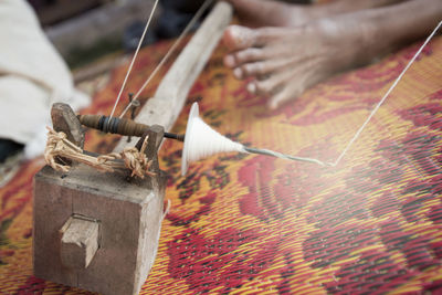 Close-up of person using spinning wheel