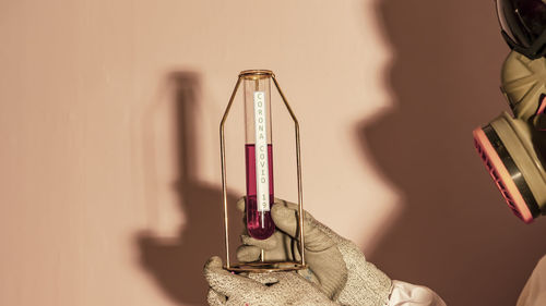 Close-up of glass bottle on table against wall