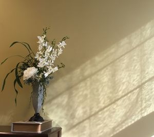 Close-up of vase on end table against the wall