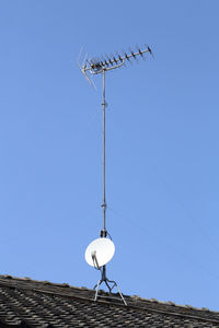 Low angle view of communications tower against clear blue sky