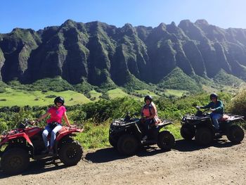 People on motorcycle against mountains