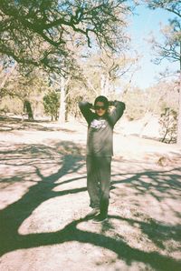 Full length portrait of man standing by tree