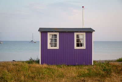 Built structure on beach by sea against sky