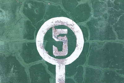 Close-up of arrow sign on wall