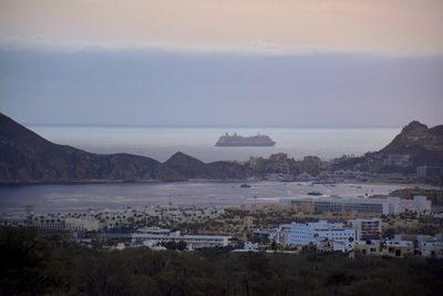 High angle view of townscape by sea against sky