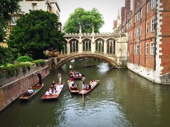 People on punt boats by bridge of sighs over river cam