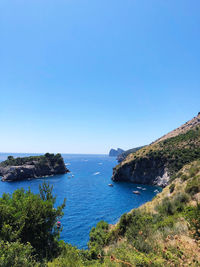 Scenic view of bay against clear blue sky