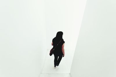 Rear view of woman walking on white background