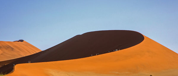 Sand dunes in desert against clear sky