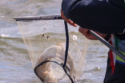 Close-up of hand holding fishing net
