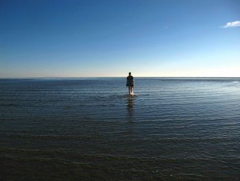 Rear view of a woman in calm blue sea