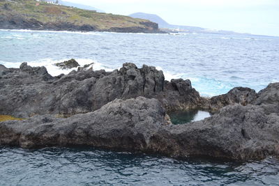 Scenic view of sea and mountains against sky