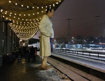 Man walking on illuminated christmas lights at night