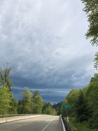 Road amidst trees against sky