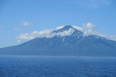 Scenic view of sea and snowcapped mountains against sky