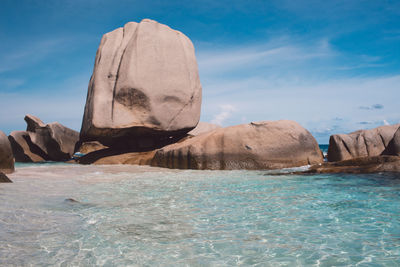 View of rock formation in sea against sky