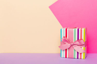 High angle view of christmas presents against pink background