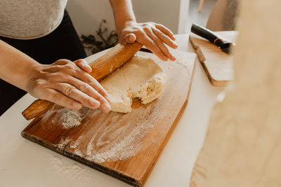 Midsection of woman rolling dough