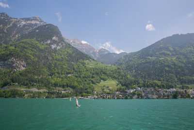 Scenic view of sea and mountains against sky