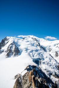 Scenic view of snowcapped mountains against clear blue sky