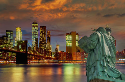 Statue of modern building against sky during sunset