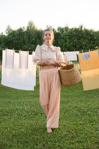 Laundry day. a woman hangs linen and towels on a tree in the courtyard of a village house.