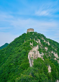 Low angle view of ruins on cliff against sky