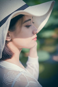 Close-up portrait of young woman wearing hat