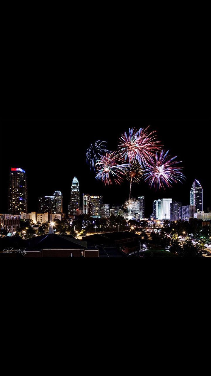 night, illuminated, building exterior, architecture, built structure, firework display, city, celebration, arts culture and entertainment, long exposure, exploding, glowing, clear sky, firework - man made object, motion, multi colored, copy space, dark, event, sky